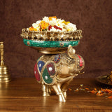 Jeweled brass elephant urli with flower-filled bowl and small floral medallion on green rim