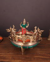 Ashtalakshmi brass urli with diyas, deity figure standing above round tray with cups
