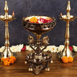 AONA brass diya stand with central urli and two side lamp holders, decorative feet