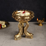 Brass fish-leg pooja urli with dangling bell rim, flowers and tea light inside