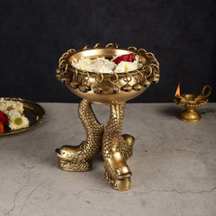 Brass vastu urli with fish feet, chained rim with dangling beads; flowers and candle