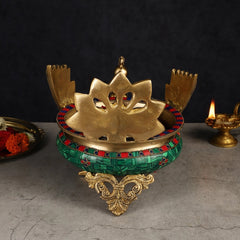 Brass peacock-shaped urli base with cutout top and decorative legs, colorful rim trim