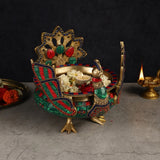 Peacock urli bowl with four arched legs, brass figure, teal-red pattern rim and flowers