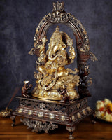Brass Ganesha statue, side view, seated with four arms and decorative pedestal