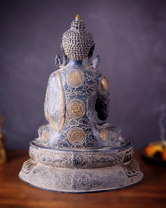 Brass Buddha statue, back view with engraved details and circular emblems