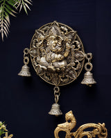 Brass Ganesh round wall hanging with detailed filigree, three bells, and dangling chain