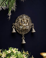 Brass Ganesh round wall hanging with central figure, arched motifs, and hanging bell