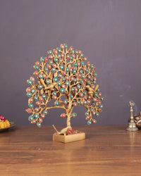 Decorative brass Kalpavriksha table tree with red/green/blue disc leaves, red pedestal base.