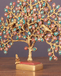 Kalpavriksha brass table tree close view: detailed trunk, multicolor leaf discs, red platform.