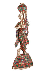 Brass Krishna figurine holding a butter pot in both hands, red-green patterned finish