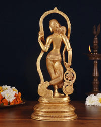 Brass lady statue seen from behind, arched halo frame and draped waist, ornate pedestal