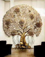 Brass Kalpavriksha tree wall art with ornate trunk, golden blossoms at the base