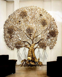 Brass Kalpavriksha tree wall art with ornate trunk, golden blossoms at the base