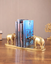 AONA brass elephant bookends holding books, spines visible on base