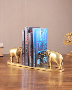 AONA brass elephant bookends holding books, spines visible on base