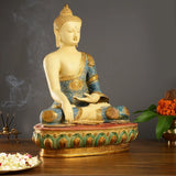 Seated Buddha statue in profile, blue robe draped over shoulder, gold highlights