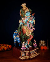 Hand-painted brass Lord Krishna statue on decorated base with calf figures, side view