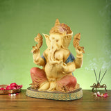 Ganesha brass figurine seated cross-legged, painted accents on blue shawl and red legs
