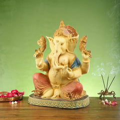 Ganesha brass figurine seated cross-legged, painted accents on blue shawl and red legs