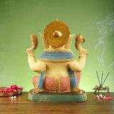 Rear view of brass Ganesha statue, rounded crown and patterned blue shawl over back