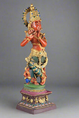 Lord Krishna murti in brass, flute near mouth, ornate crown with blue accents