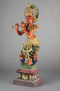 Pure brass Krishna statue holding a flute, teal and gold clothing on pedestal