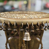 Close-up of brass chowki rim with rows of tiny bells and metal support base