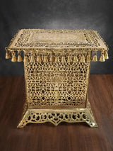 Brass rectangular chowki with ornate filigree top and row of bell-like knobs