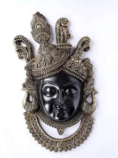 Close-up of brass Shrinathji wall decor with black face and detailed crown