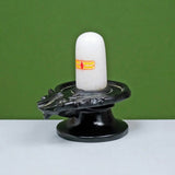 Shivling sculpture with white lingam on dark carved base, 7 inches high