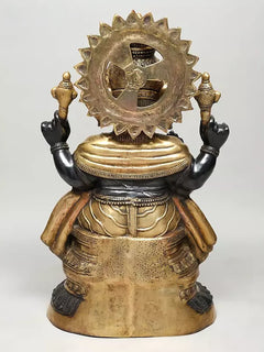 Brass Ganesha sculpture, back view with halo-like disc, crown, and draped ornaments