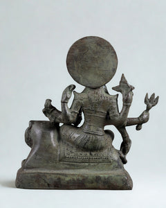 Rear view bronze Durga seated on lion pedestal, 7 in, circular halo visible