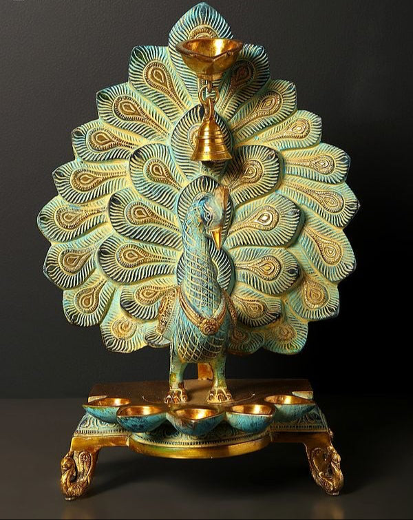 Brass peacock oil lamp with hanging bell, multi-wick top and teal-blue feather accents