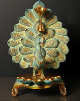 Brass peacock oil lamp with hanging bell, multi-wick top and teal-blue feather accents