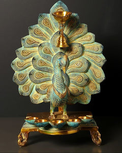 Brass peacock oil lamp with hanging bell, multi-wick top and teal-blue feather accents