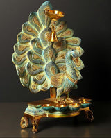 Brass peacock oil lamp on round base tray with six wick openings and hanging bell