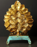 Gilded lotus-style base of the peacock oil lamp with teal pedestal feet and gold sheen