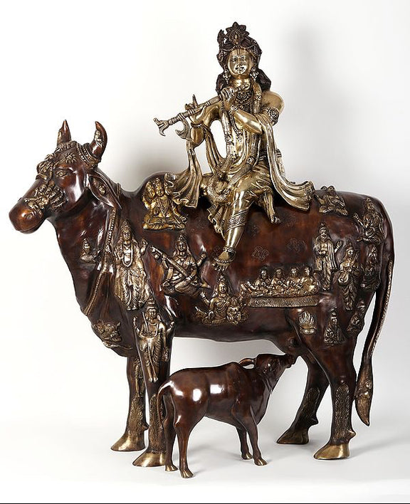 AONA Krishna idol seated on cow figurine, dark brown and gold ornamented detailing