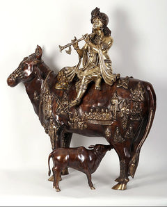 Krishna idol on cow figurine with small calf, dark brown and gold embossed figures