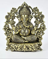 Brass seated Ganesha statue with ornate crown, trunk forward, decorative halo and base