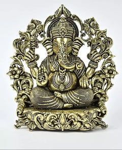 Brass seated Ganesha statue with ornate crown, trunk forward, decorative halo and base