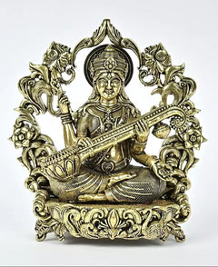 Brass seated Saraswati statue playing veena, ornate halo, patterned sari robe and crown