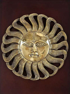 Gold sun-face relief with flowing hair rays, detailed eyes and smile on dark backing