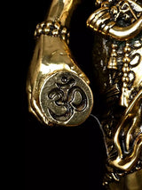 Close-up of Shiva brass idol hand and engraved circular emblem with trident base