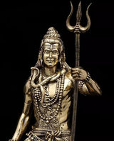 Close-up brass Lord Shiva idol face and upper body, trident held upright, beadwork detail