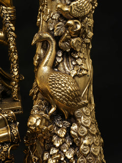 Brass Radha-Krishna idol ornament close-up: decorated surface and floral motifs.