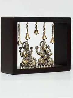 Front view of brass Lakshmi and Ganesha wall hanging inside dark frame