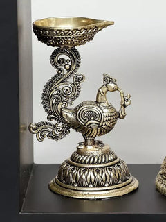 Brass decorative lamp bowl with peacock figure base, part of the Lord Krishna wall hanging
