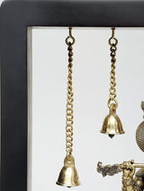 Hanging bell chains and small brass bells above the Lord Krishna wall hanging frame