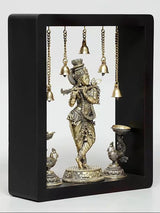 Framed brass Lord Krishna wall hanging with hanging bells and lamp bowls on both sides